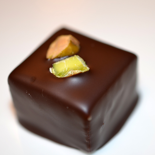 A dipped chocolate decorated with pistachios